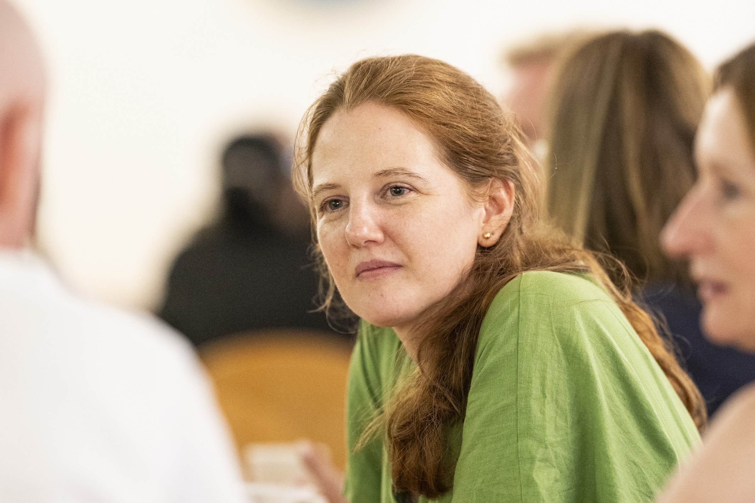 A woman listening attentively during a School of Philosophy discussion