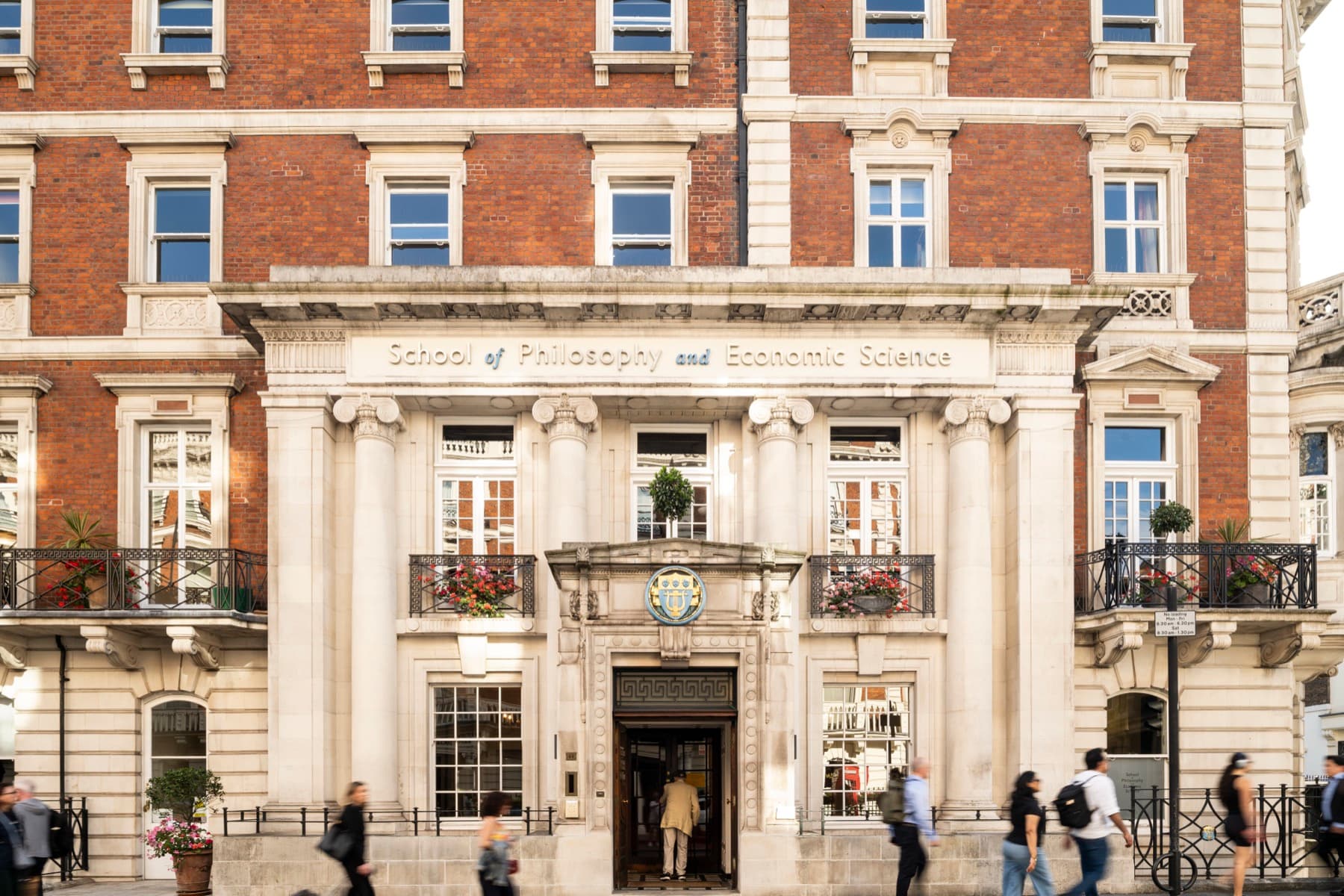 Mandeville Place street facade with the School name above the columns; people on the pavement